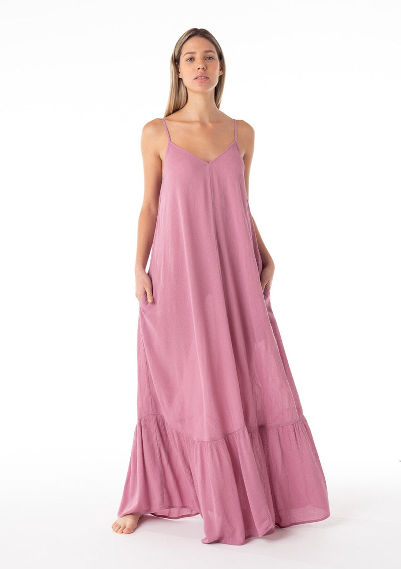 [Color: Smokey Orchid] A front facing image of a blonde model wearing a simple flowy sleeveless maxi tank dress in a light purple crinkle rayon. With a v neckline in front and back, adjustable spaghetti straps, and a tiered skirt. 