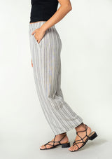 [Color: White/Black] A front facing image of a brunette model wearing a bohemian wide leg lounge pant in a white and black stripe. With side pockets and an elastic waistband. 