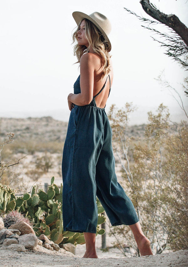 [Color: Dark Wash] Lovestitch lightweight, cropped gaucho wide leg tencel jumpsuit featuring keyhole tie front detail, criss-cross strappy back, adjustable skinny straps and side pockets.