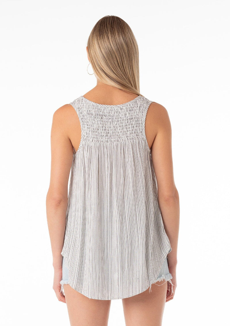 [Color: Off White/Black] A back facing image of a blonde model wearing a casual bohemian spring tank top in an off white and black stripe. With a v neckline, a smocked yoke detail, and a relaxed fit. 