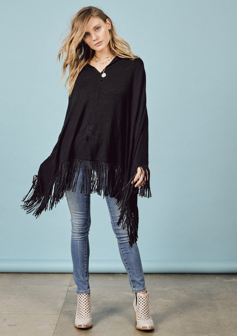 [Color: Black] A front facing image of a blonde model wearing a black suede fringed poncho. 