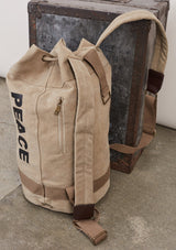[Color: Beige] A cotton blend beige sack backpack with a drawstring closure. 