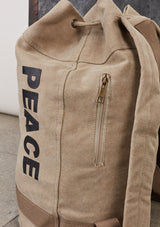 [Color: Beige] A cotton blend beige sack backpack with a drawstring closure. 