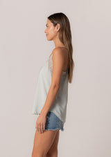 [Color: Mint] A side facing image of a brunette model wearing a light mint green camisole tank top. With spaghetti straps, a v neckline, lace trim, a racerback, and a relaxed fit. 