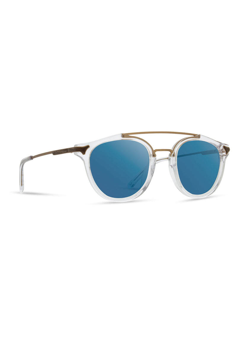 [Color: Crystal] Clear Italian acetate sunglasses with contemporary round lens, metal brow bar, and wood accents.