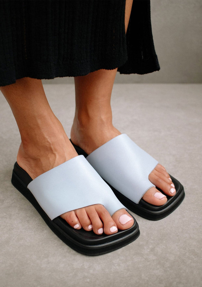 [Color: Baby Blue] Alohas baby blue flop leather flat slip on sandal with a toe ring detail. 